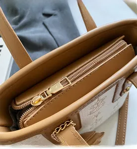 Detailed close-up of brown leather bucket bag showing metal zipper and embossed texture