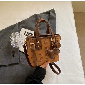 Detailaufnahme der braunen PU-Ledertasche mit Sternprägung und Hunde-Anhänger