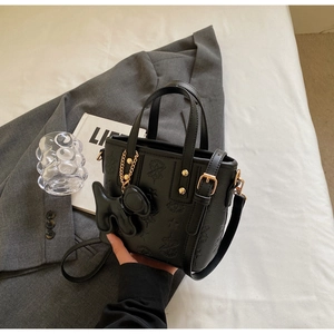 Detail der schwarzen Bucket Bag mit Stern-Prägung, Hundehänger und goldener Kette