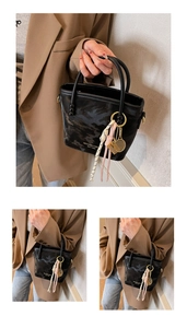 Detail der schwarzen Camo-Beuteltasche mit Tennis-Anhänger und Markenlogo
