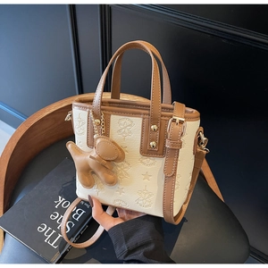Detail der zweifarbigen Beuteltasche mit Sternenmuster und braunem Hundeanhänger