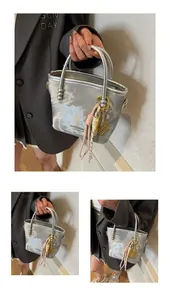 Detail der silbernen Marmor-Beuteltasche mit Zieranhängern und Markengravur