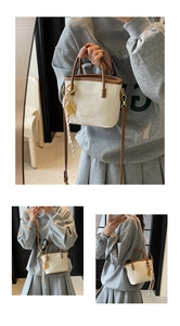 Detail der cremefarbenen Beuteltasche mit braunem Lederbesatz und Tennisschläger Anhänger
