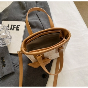 Detail of star-embossed tote with interior zipper compartment and beige leather texture