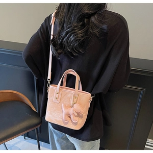 Sac seau rose avec gaufrage de dessin animé et breloque chien porté par un mannequin