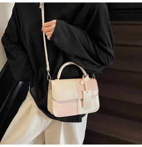 Detail view of pink and off-white color-block handbag with smooth synthetic leather