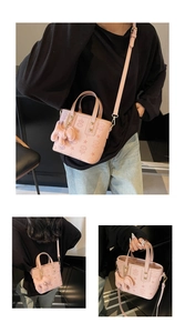 Detailed macro view of pink embossed mini tote with star patterns and plush doll charm