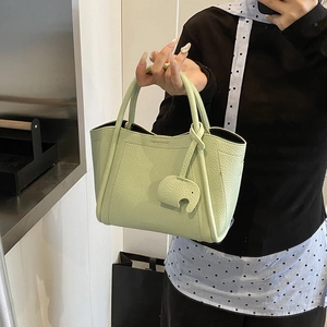 Stylish light green litchi grain mini bucket bag with a cute elephant leather charm