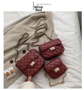 Detail of burgundy quilted leather bags with metal turn-lock and chain straps