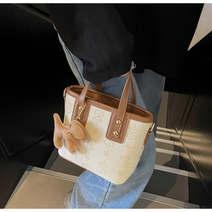 Draufsicht auf eine creme-braune Beuteltasche mit Sternenprägung und einem Hundeanhänger