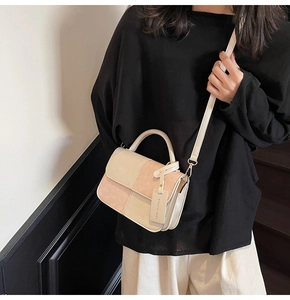 Detail of beige faux leather and pink suede patchwork bag with top handle and strap