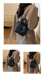 Detail of black embossed bucket bag featuring a star pattern and a dog charm accessory