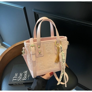 Dettaglio della borsa a secchiello in pelle rosa con motivi a stella e finiture dorate