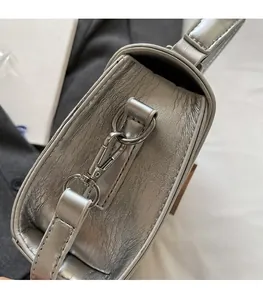 Détail de sac en cuir argenté brillant avec finitions métalliques élégantes