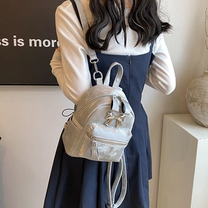 Mini sac à dos argenté pour femme avec texture plissée métallique et nœud doré élégant