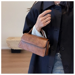 Close-up of caramel brown leather handbag with gold Fashion & Bags logo lettering