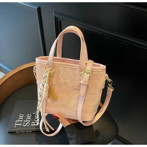 Dettaglio borsa tote rosa con stelle goffrate, nappa a frange e ciondolo ad abaco dorato