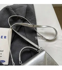 Détail de la bandoulière réglable argentée avec texture métallique sur un sac pour femme