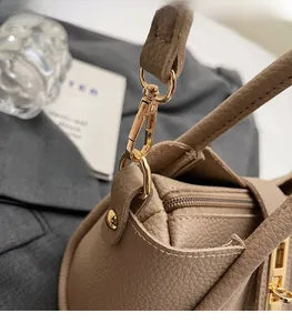Detail of light gold hardware and litchi grain texture on khaki bucket handbag