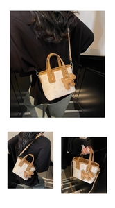 Detail of a mini bucket bag featuring embossed star patterns and brown leather straps