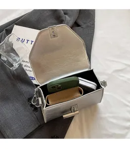 Détail du sac argenté métallisé montrant la capacité intérieure et le fermoir