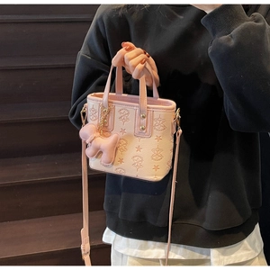 Rosa Handtasche mit Sternenprägung, Hundeanhänger und goldenen Details auf dunklen Stufen
