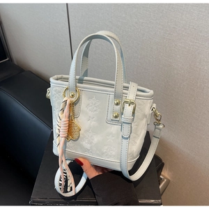 Dettaglio della borsa a secchiello azzurra con stelle a rilievo e foulard di seta