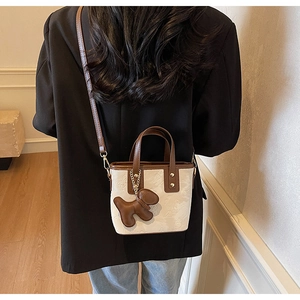Sac fourre-tout beige chic avec garniture en cuir brun et breloque chiot sur modèle