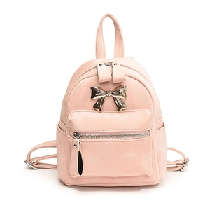 Mini sac à dos rose pour femme avec nœud doré et poche zippée avant sur fond blanc neutre