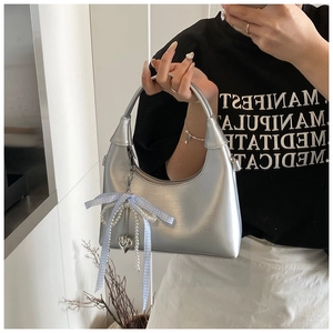 Détail du sac à main croissant argenté avec texture brossée et perles de charme