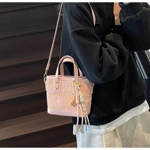 Dettaglio della borsa tote in pelle rosa goffrata con motivi a stelle e farfalle