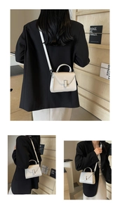 Détail du sac à main en cuir blanc avec fermoir en métal argenté et poignée supérieure