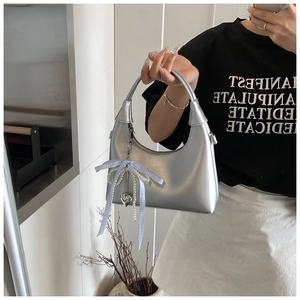 Détail du sac hobo argenté avec nœud bleu et charms en perles en forme de cœur