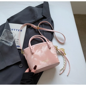 Detail der rosa Bucket Bag mit Marmortextur, goldener Hardware und Tennis-Anhänger