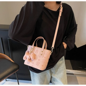 Detail of pink bucket bag with embossed star pattern and cross-texture finish