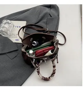 Dettaglio della grande capacità interna della borsa a mano in pelle marrone con foulard