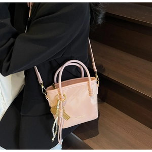 Detail der rosa Bucket Bag mit Marmormuster, goldenen Beschlägen und Quastenanhänger