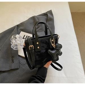 Détails du sac à main en cuir noir avec motifs papillons et finitions dorées