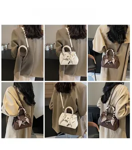 Dettaglio della mini borsa stile Kelly con foulard di seta avvolto sul manico