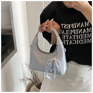 Détail du sac hobo en cuir PU bleu clair avec breloque en perles et ruban à nœud