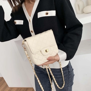 Elegant cream quilted crossbody bag with gold chain strap and metallic twist lock