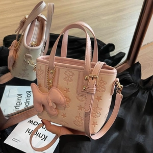 Rosa und beige Beuteltasche mit Sternprägung und Hundeanhänger im Spiegel gezeigt