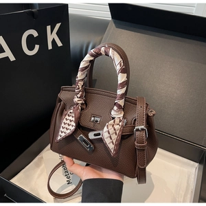 Dettaglio borsa in pelle testa di moro con foulard in seta e chiusura in metallo argento