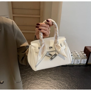 Dettaglio della borsa in pelle bianca a grana litchi con fibbia argento e foulard in seta