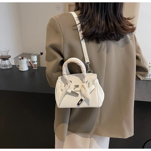 Dettaglio borsa bianca in pelle martellata con manico in seta floreale e chiusura
