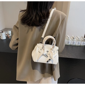 Dettaglio della borsa in pelle martellata bianca con chiusura argento e sciarpa
