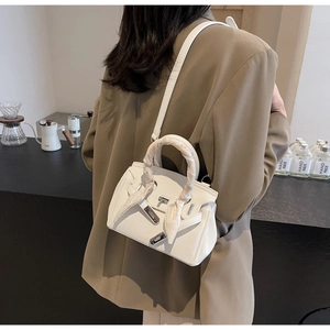 Dettaglio borsa a mano in pelle bianca con foulard in seta e chiusura in argento