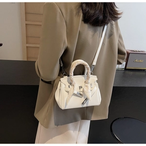 Dettaglio della borsa bianca in pelle con chiusura argento e foulard decorativo in seta