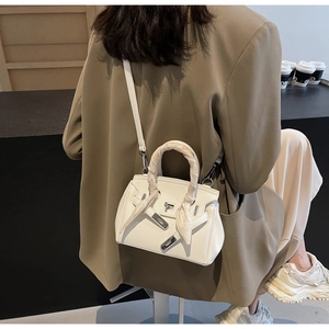 Dettaglio borsa a mano bianca in pelle con manico in seta floreale e chiusura argento