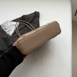 Detailed bottom view of large beige quilted tote bag with soft leather texture and thick base